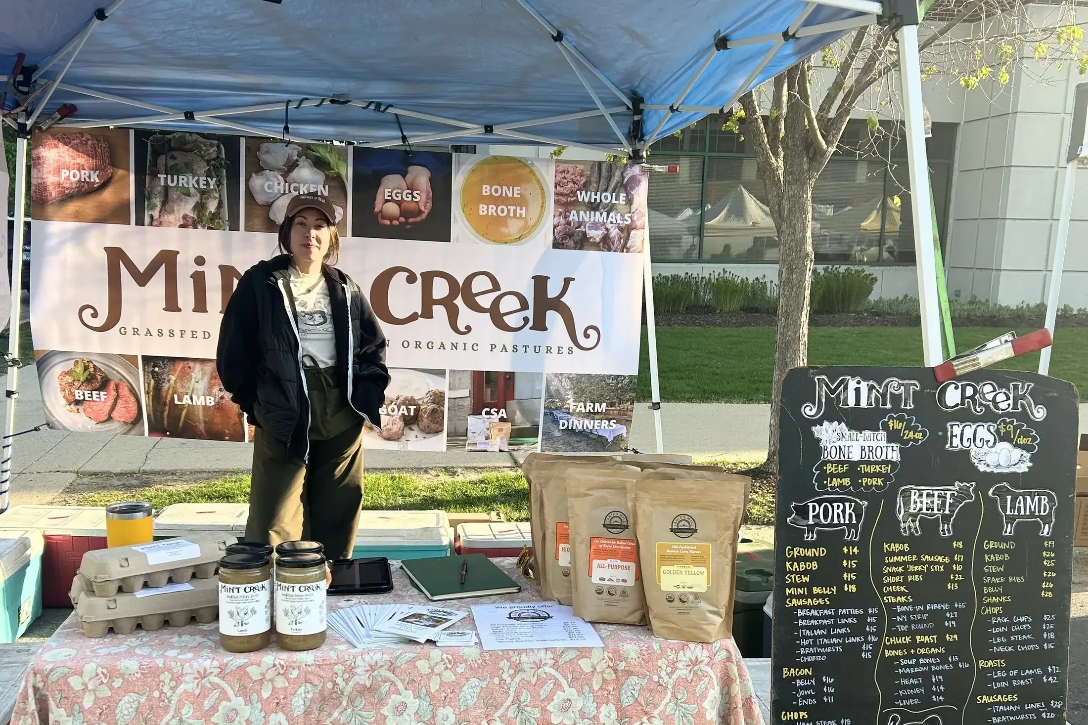 Market staff with goodies laid out on the table at farmers’ market